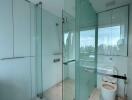 Modern bathroom with glass shower enclosure and city view