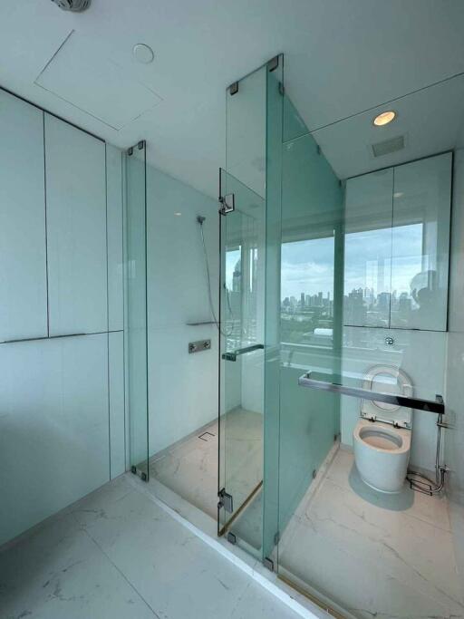 Modern bathroom with glass shower enclosure and city view