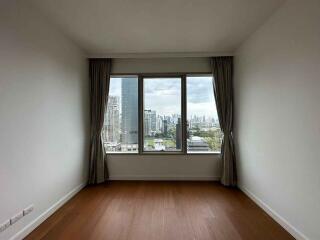 Empty bedroom with large window and city view