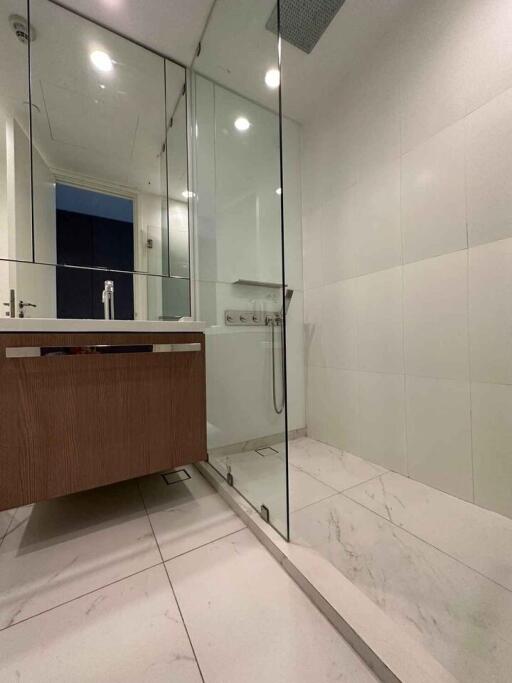 Modern bathroom with glass shower and wooden vanity