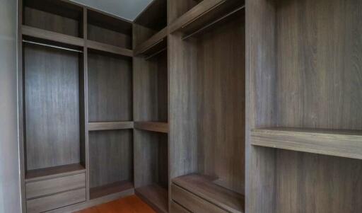 Spacious walk-in closet with wooden shelves and drawers