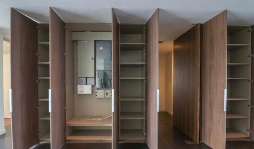 closet with open doors showing shelves and electrical panel