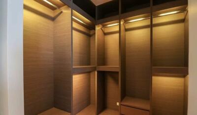 Spacious and well-lit walk-in closet with wooden shelves