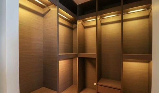 Spacious and well-lit walk-in closet with wooden shelves