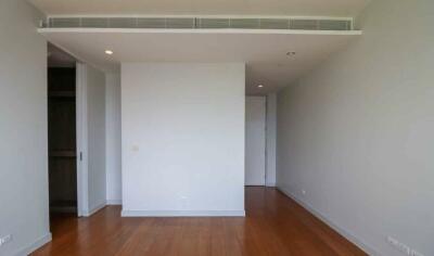 Empty bedroom with wooden flooring and air conditioning vent