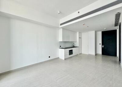 Modern kitchen and living area with white cabinets and tiled floor