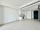 Modern kitchen and living area with white cabinets and tiled floor