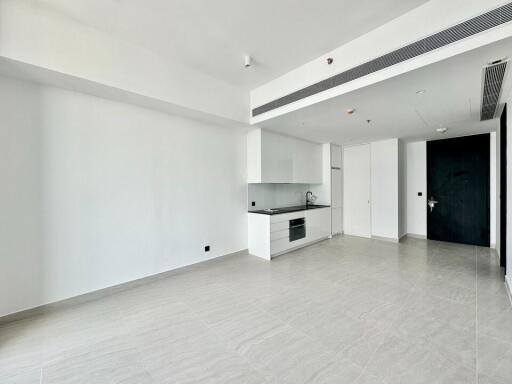 Modern kitchen and living area with white cabinets and tiled floor