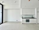 Modern minimalist kitchen with white cabinetry and black countertops