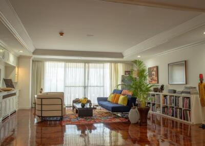 Spacious and well-lit living room with a sitting area, large windows, and polished floors.