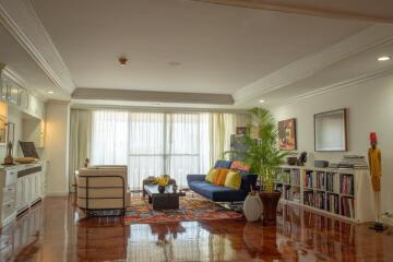 Spacious and well-lit living room with a sitting area, large windows, and polished floors.