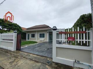 Front view of the house with driveway and lawn