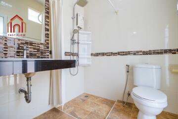 Modern bathroom with toilet, sink, shower, and tiled walls