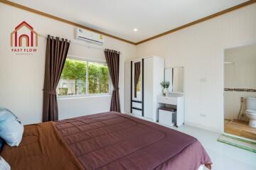 Cozy bedroom with a large window, wardrobe, and ensuite bathroom