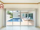 Spacious living area with glass doors opening to poolside view