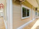 Exterior view of a house's side with beige siding and white trim