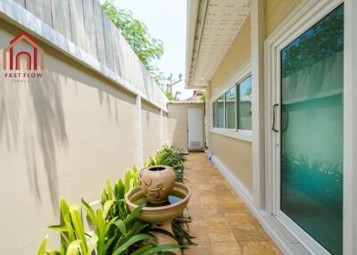 Exterior side walkway of a property with plants and water feature