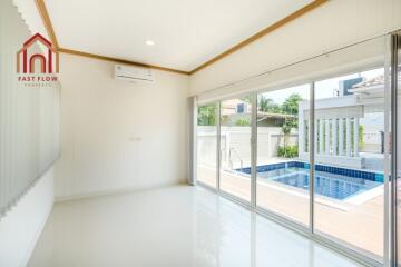 Modern living room with large sliding doors leading to a swimming pool