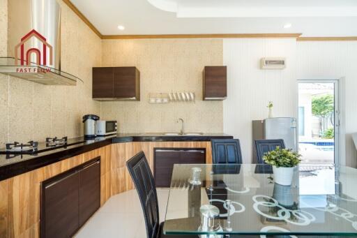 Modern kitchen with dining area and pool view