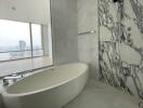 Modern bathroom with marble finishes and a large oval bathtub