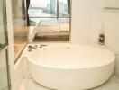 Luxury bathroom with a bathtub and a view of the bedroom and city skyline