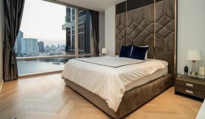 Modern bedroom with a large bed and city view through the window