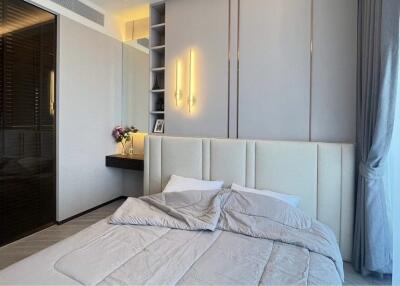 Modern bedroom with minimalist design featuring a large bed, built-in vanity, and soft lighting