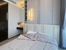 Modern bedroom with minimalist design featuring a large bed, built-in vanity, and soft lighting