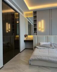 Modern bedroom with plush bed, built-in lighting, and a small vanity area