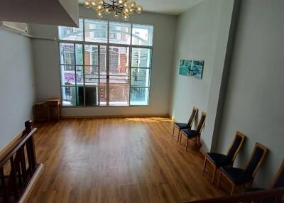 Spacious living room with wooden flooring and large windows