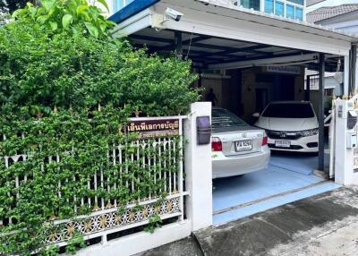 Covered garage with two parked cars and green plant wall