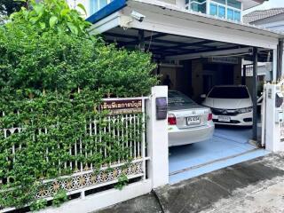 Covered garage with two parked cars and green plant wall