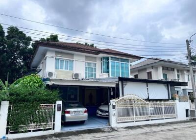 Two-story residential house with driveway and gate