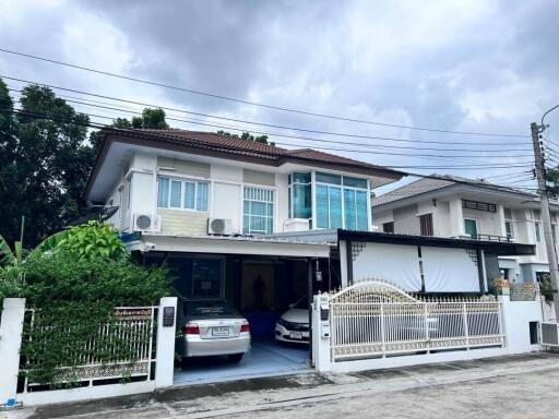 Two-story residential house with driveway and gate