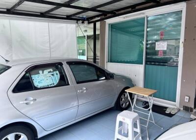 Covered garage with car, table, and chairs