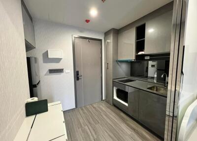 Modern kitchen area with sleek grey cabinets and built-in appliances