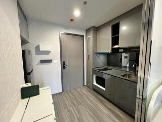 Modern kitchen area with sleek grey cabinets and built-in appliances