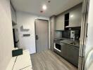 Modern kitchen area with sleek grey cabinets and built-in appliances