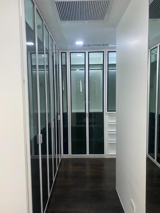 Modern walk-in closet with glass doors