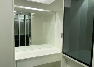 Modern walk-in closet with built-in storage and a vanity mirror