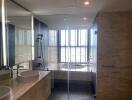 Modern bathroom with twin sinks, glass-enclosed shower, and a bathtub with a large window