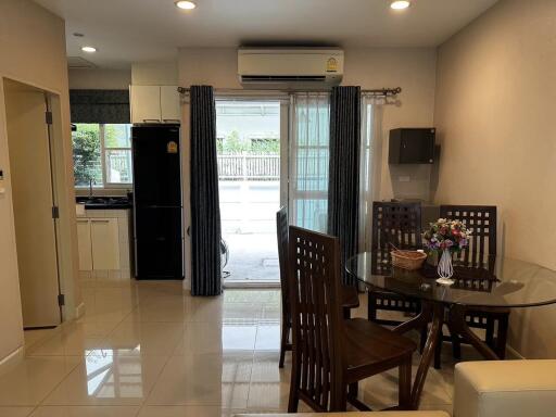 Dining area with table and chairs, view of kitchen and outdoor space