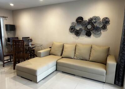 Modern living room with beige sectional sofa and dining area