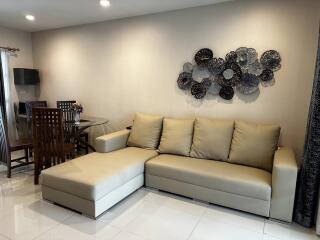 Modern living room with beige sectional sofa and dining area