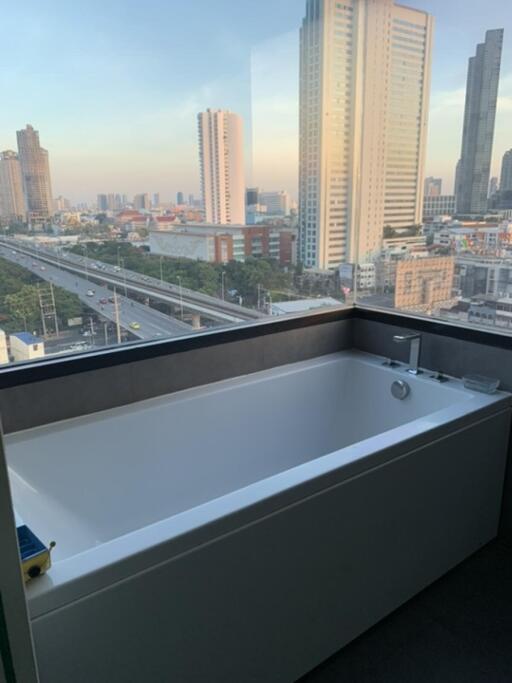 Bathroom with a large bathtub and a city view