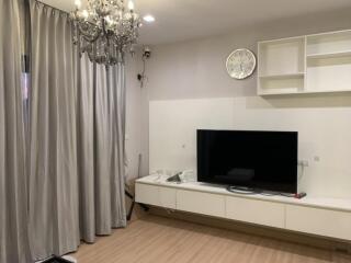 Modern living room with chandelier and mounted TV