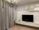 Modern living room with chandelier and mounted TV