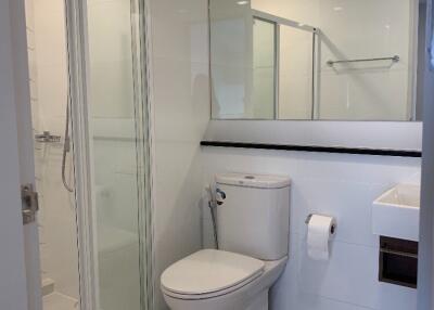 Modern bathroom with glass shower, toilet, and sink