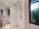 Modern bathroom with walk-in shower, sink, and large window