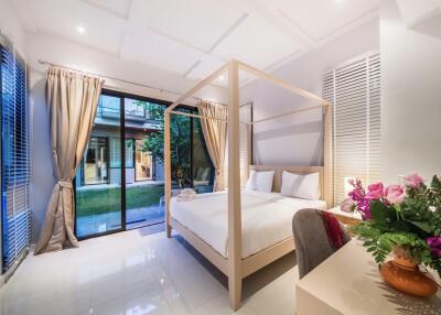 Spacious bedroom with a canopy bed and large windows